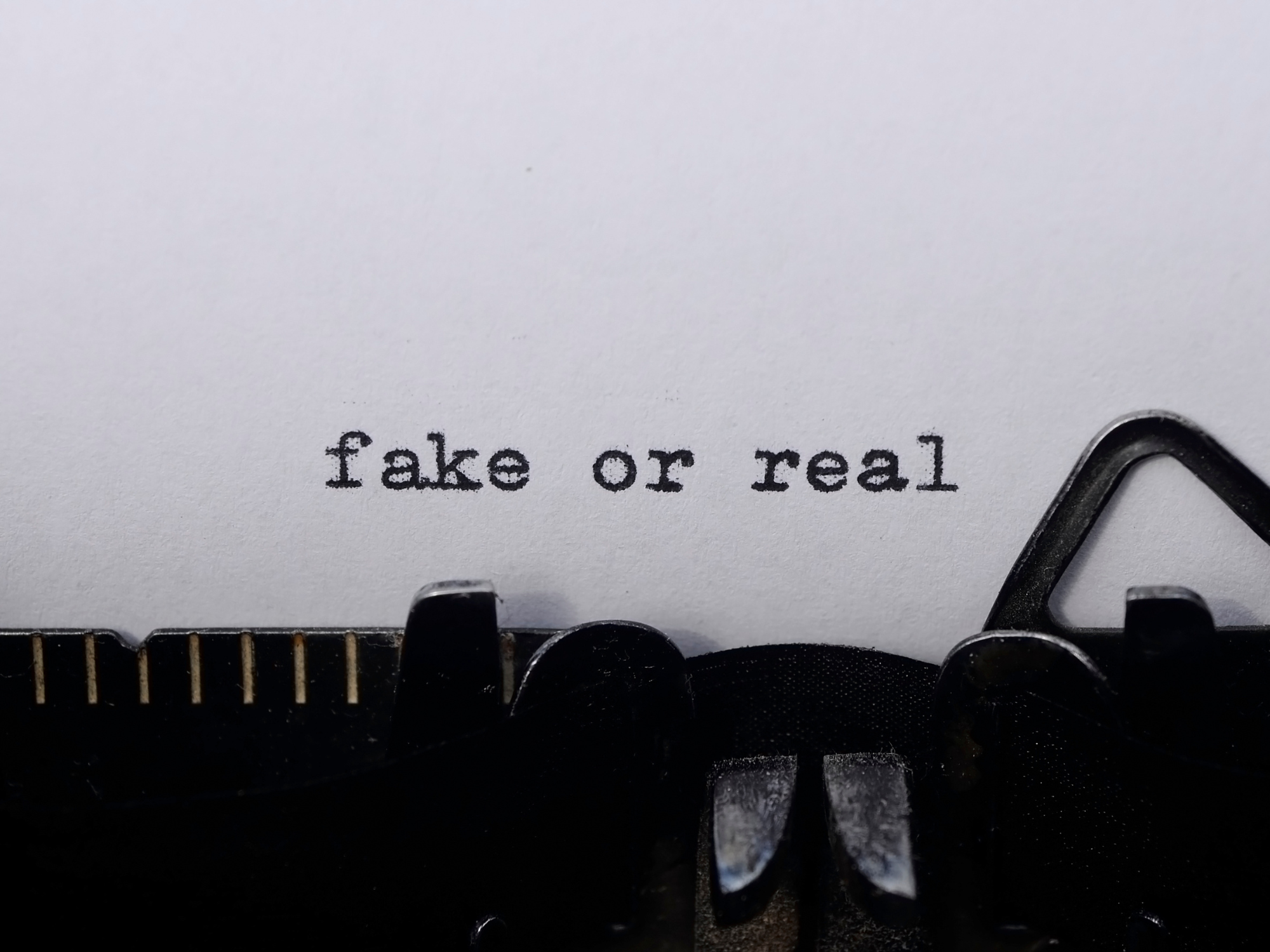 The words "fake or real" on a typewriter, representing the importance of identifying authentic, real, high-quality Shilajit and avoiding counterfeits.