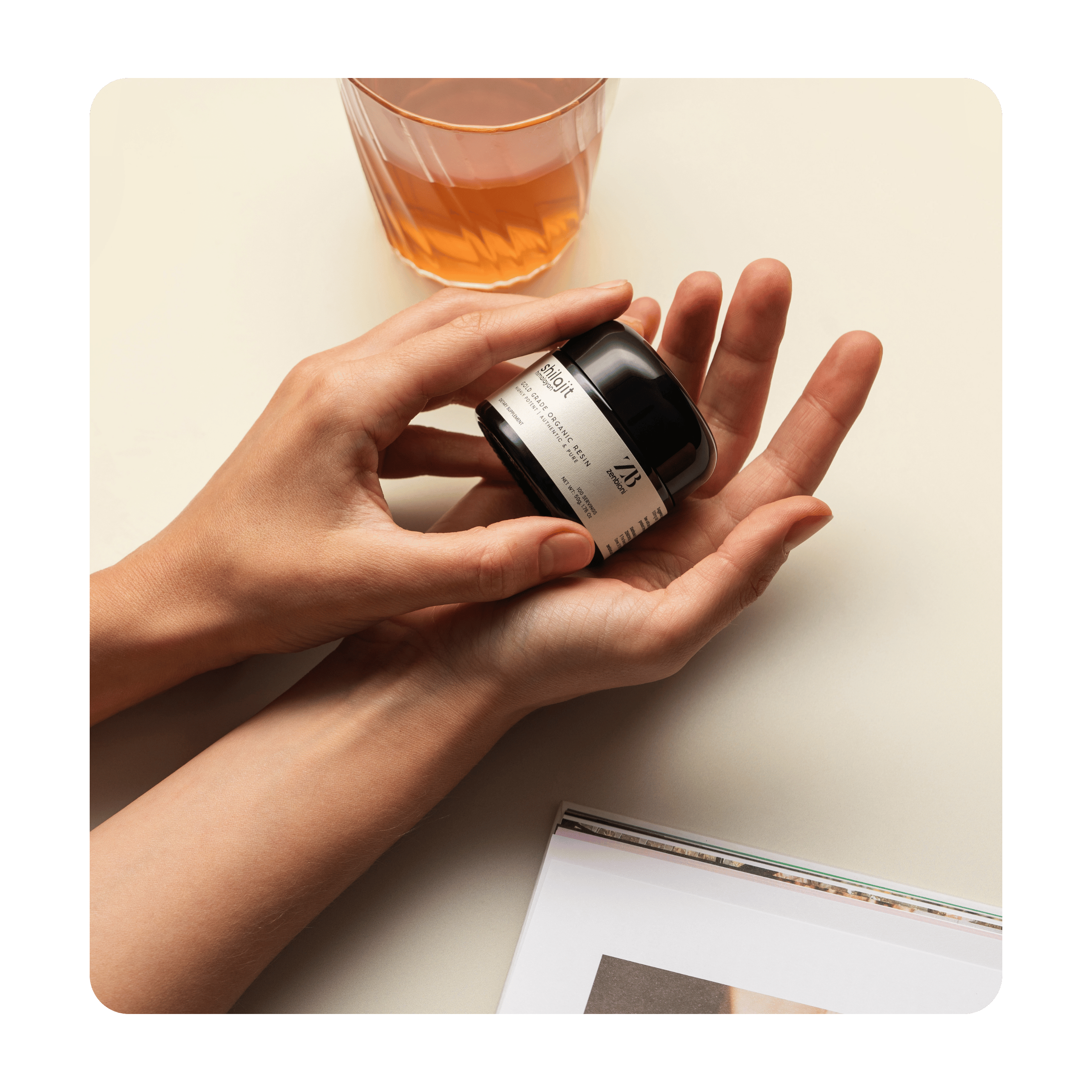 Hands delicately holding Zenbioni Himalayan Shilajit resin jar, showcasing premium quality and natural product.