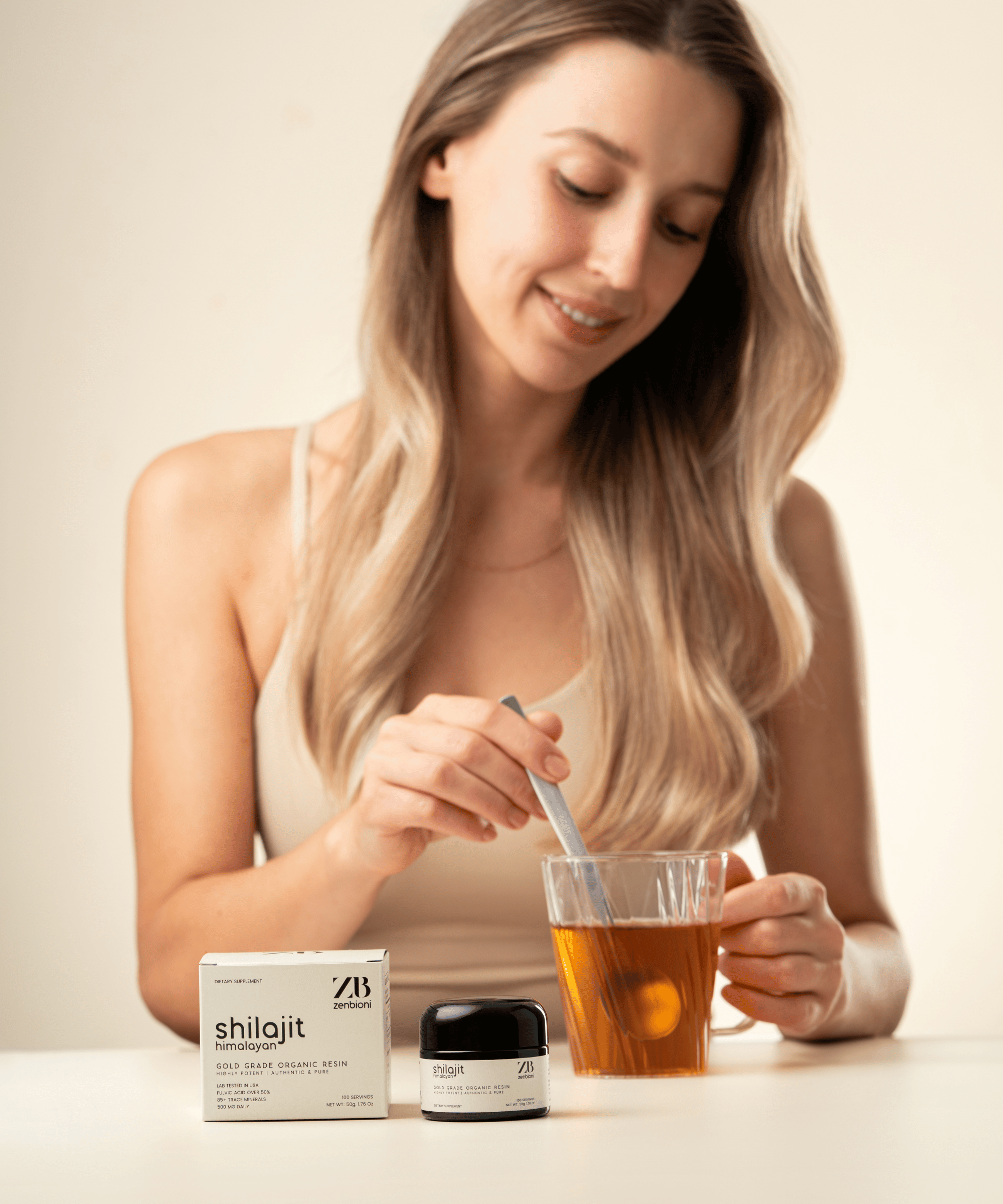 Preparing Zenbioni Shilajit tea. Woman stirring Shilajit resin into hot tea.